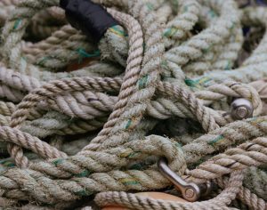 Detailed shot of old, coiled jute ropes intertwined in a nautical environment.